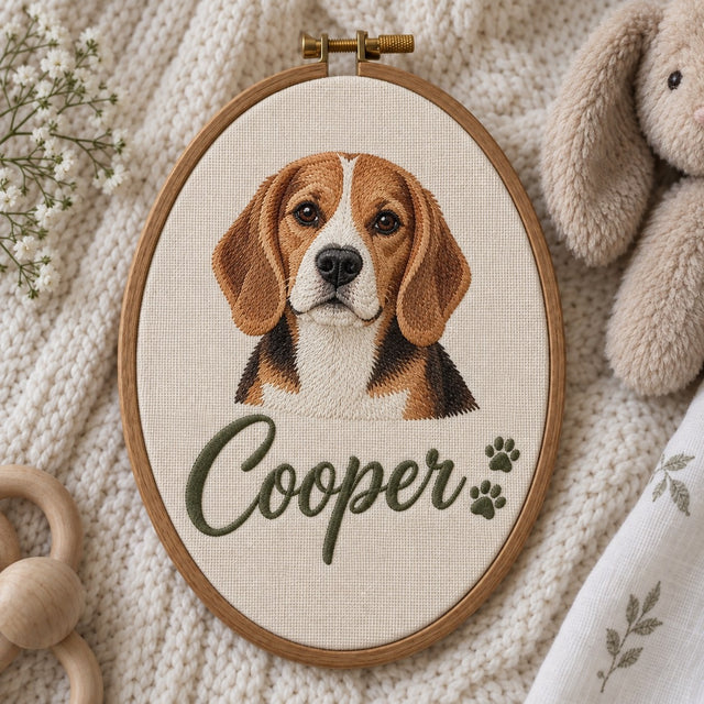 Machine-embroidered pet name hoop: a small beagle portrait above the name Cooper in script with two paw prints, oval wooden hoop